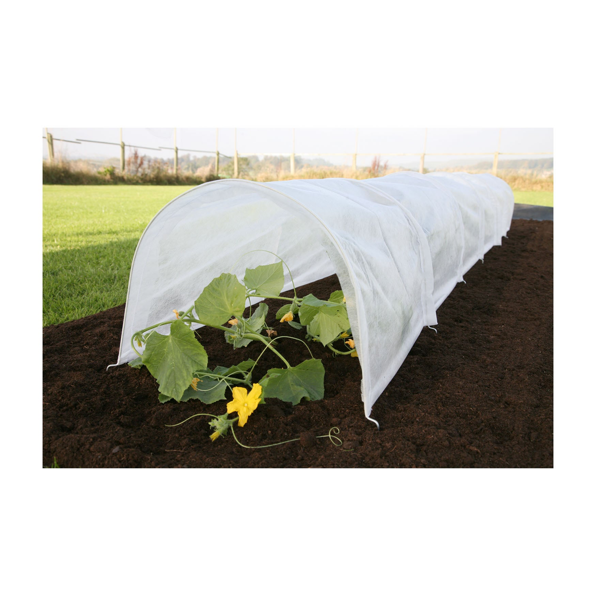 Easy Fleece Garden Tunnel providing plant protection and insulation on garden soil, dimensions 118&quot;L x 18&quot;W x 12&quot;H.