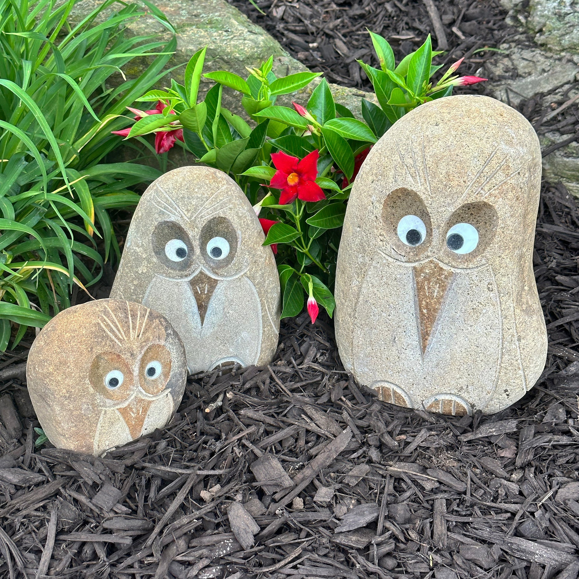 Hand-carved granite boulder stone angry birds set in a garden.