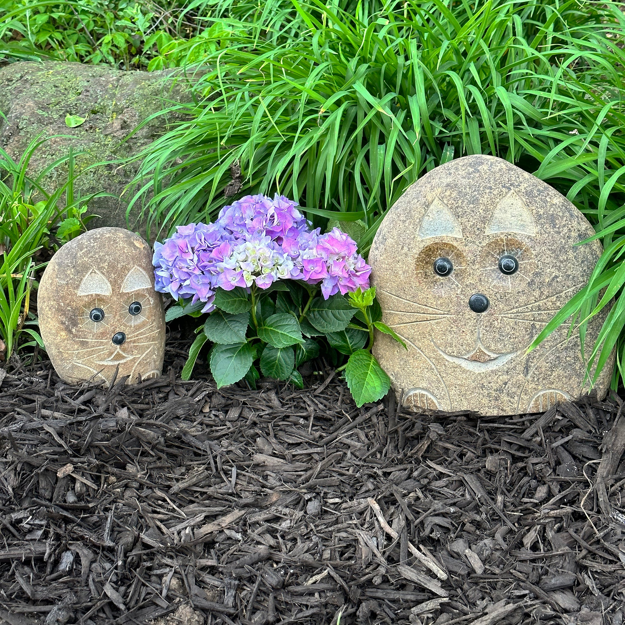 Hand-carved natural granite boulder stone cat sculptures in garden decor.