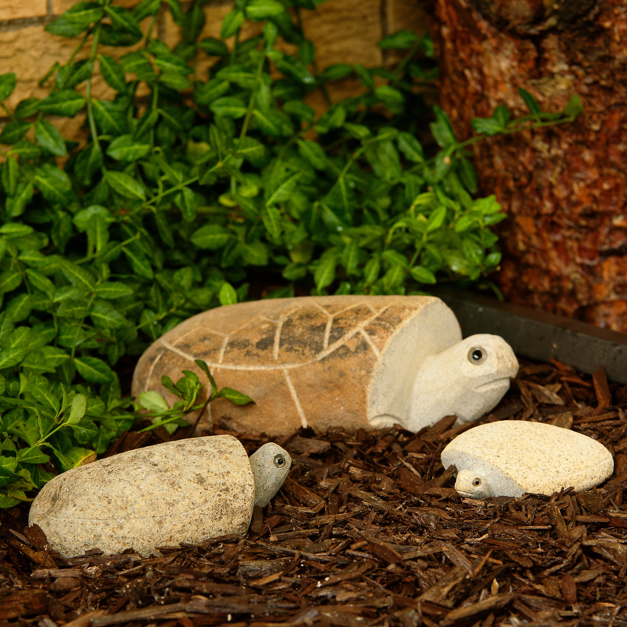 Hand-carved natural granite boulder stone turtle family in garden setting, eco-friendly decor.