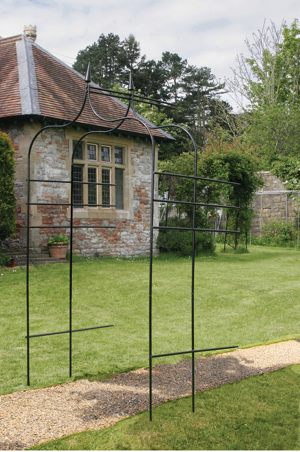 Gothic Style Garden Arch Extension Kit installed in a garden with stone building backdrop.