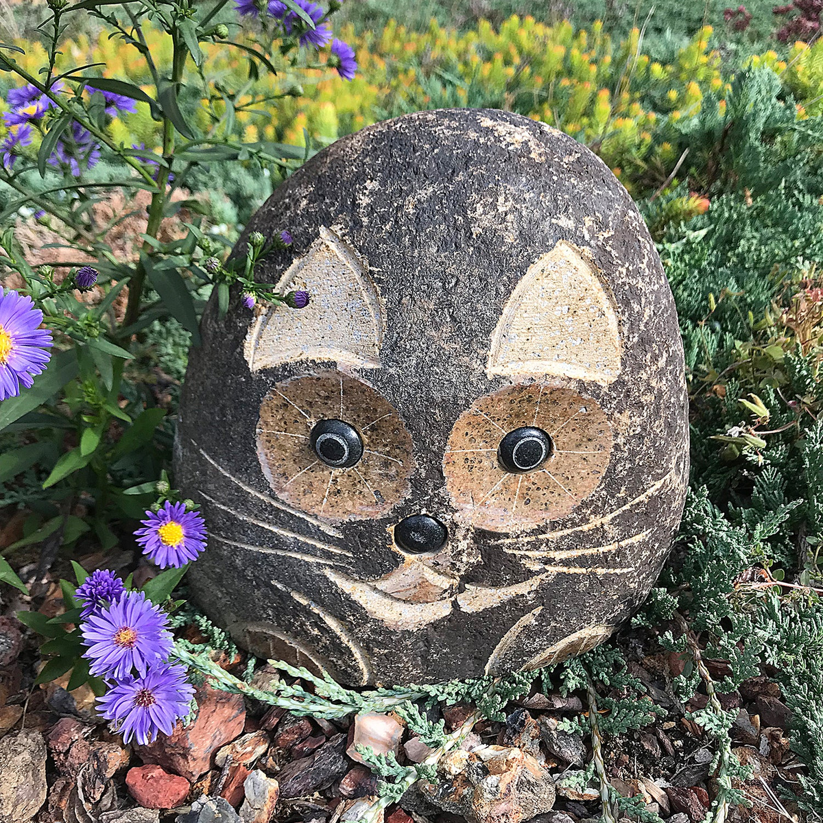 Hand carved natural granite 8&quot; boulder stone cat with unique details in garden setting.