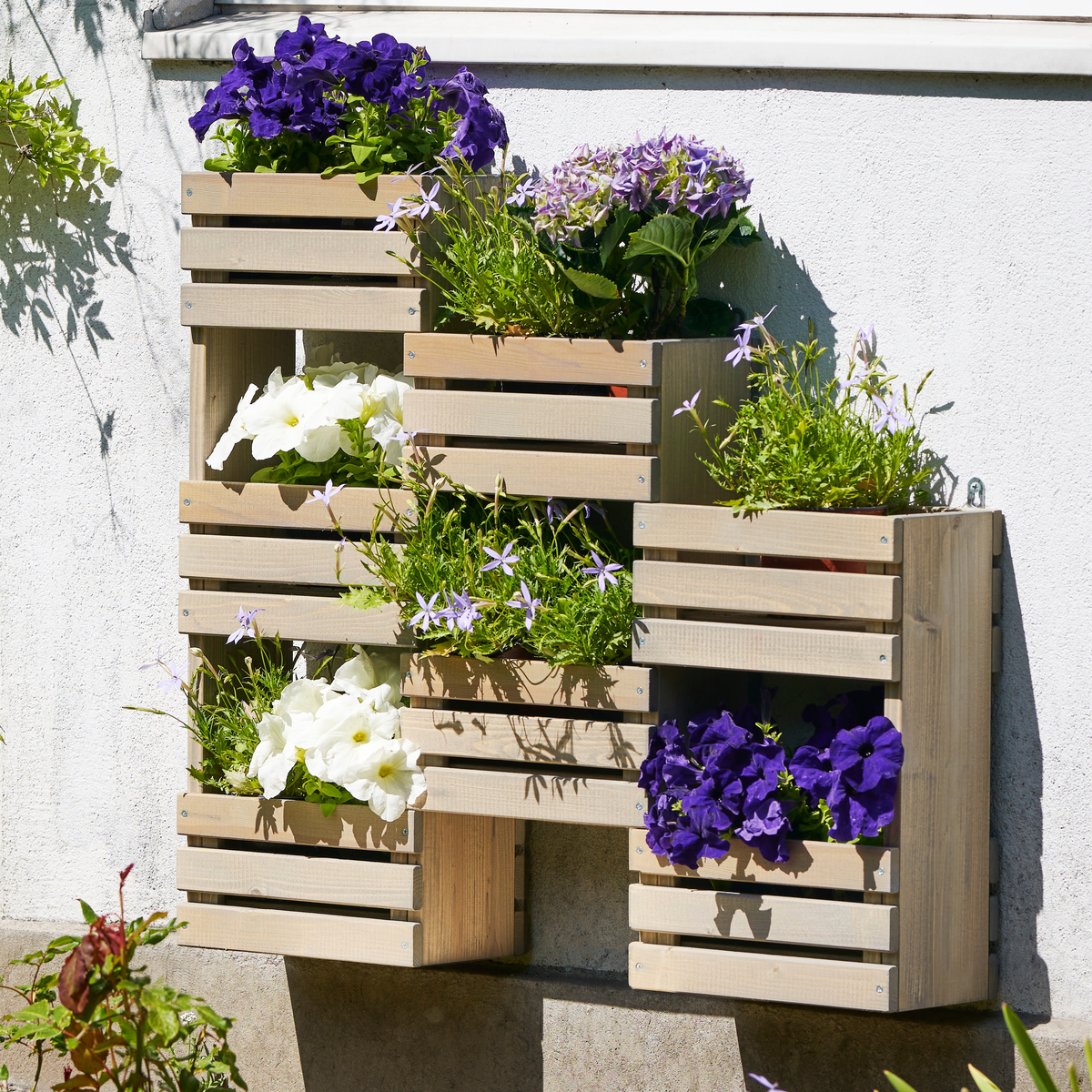 Tiered Wooden Hanging Garden Wall Planter with seven shelves displaying flowers.