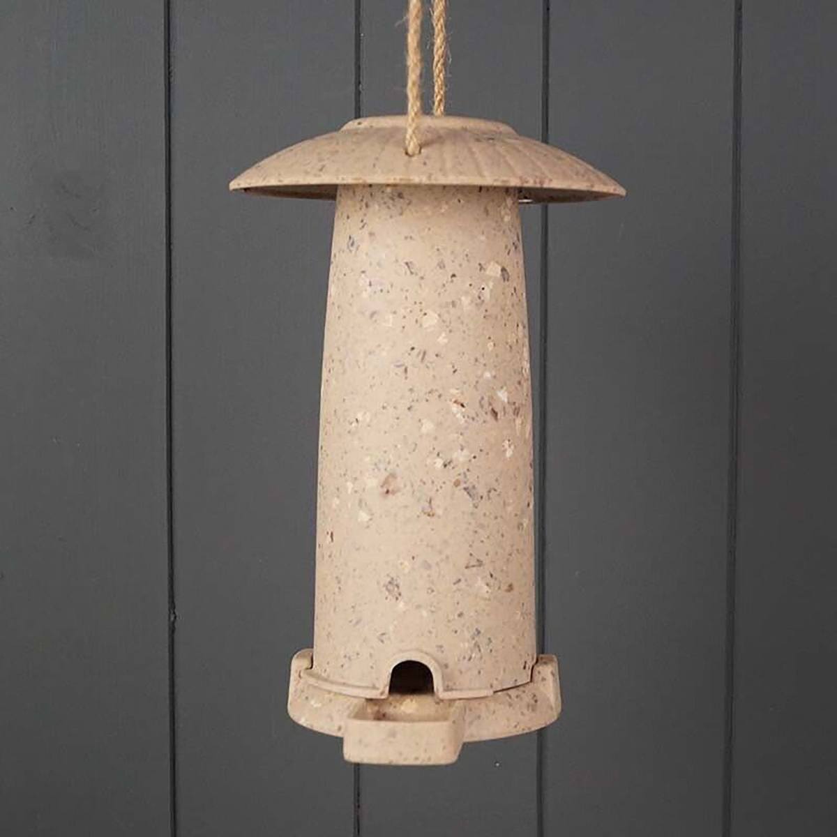 Eco-friendly seed feeder made from coffee husks, suitable for indoor and outdoor use.