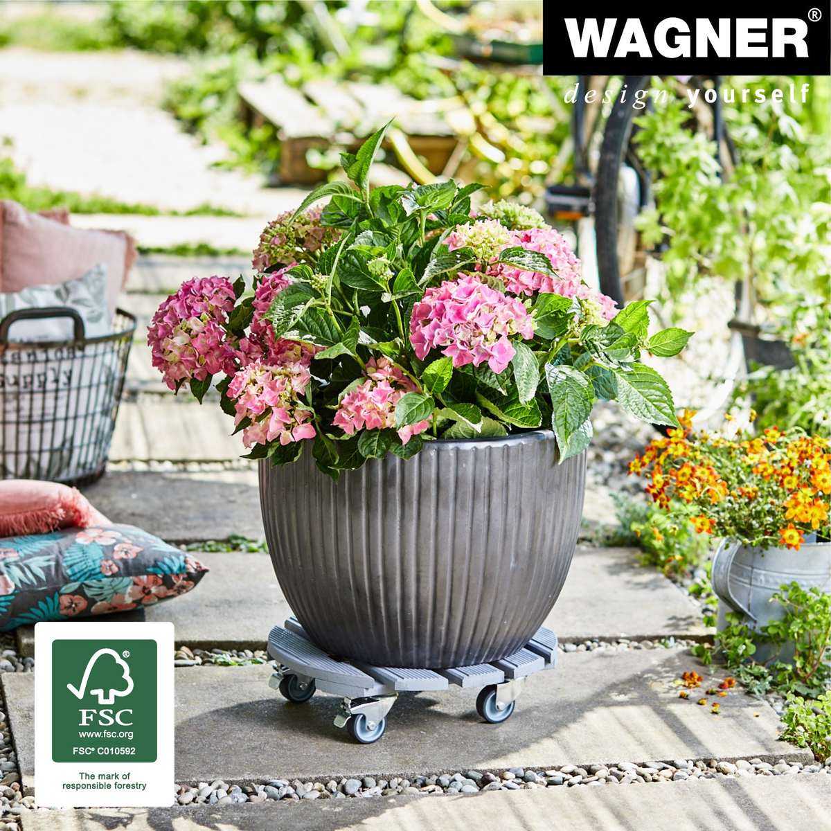 15&quot; gray round ribbed indoor plant caddy with pink hydrangea in garden setting