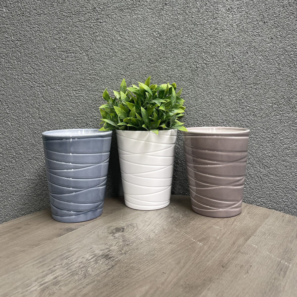 3-piece indoor ceramic orchid plant pot set in white, blue-gray, and warm-gray on a wooden surface.