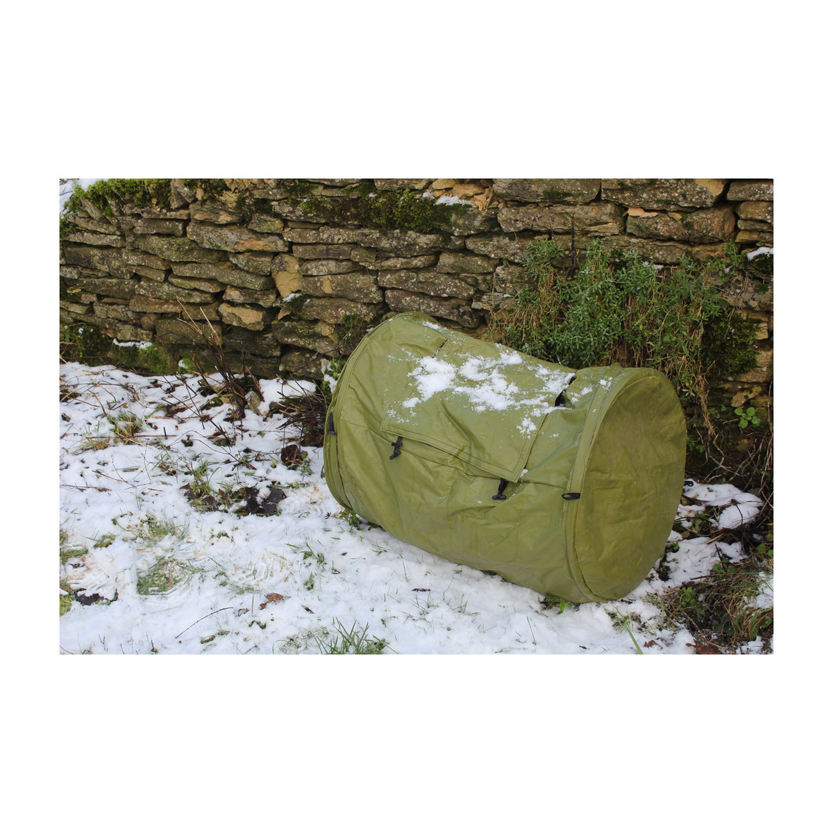 Green Rollmix Composter in a snowy garden setting, 26&quot; L x 22&quot; D, ideal for small spaces.