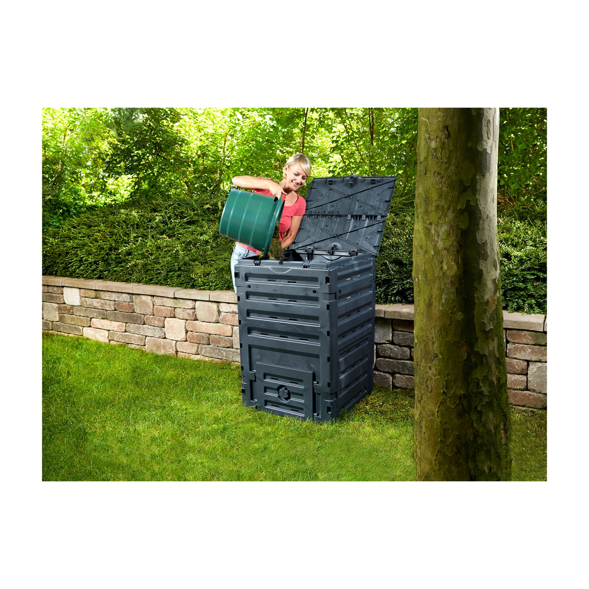 79 Gallon Capacity Eco Master Composter in garden setting with person adding waste.