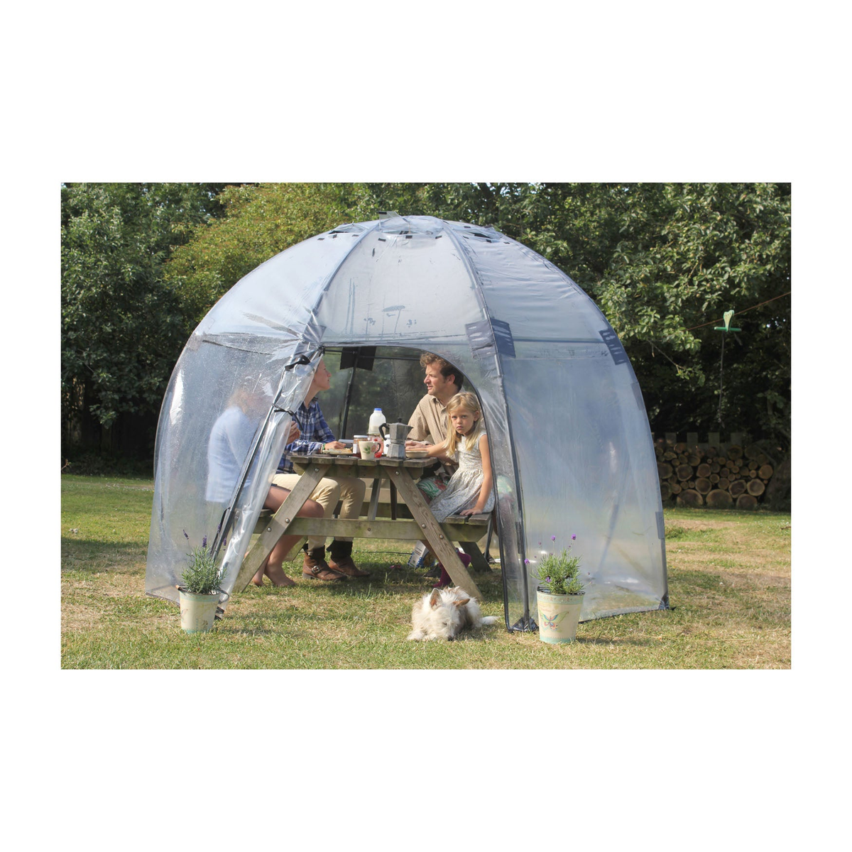 Walk-in greenhouse Sunbubble by Haxnicks with people enjoying a meal inside, showcasing the dome structure and transparent PVC design.