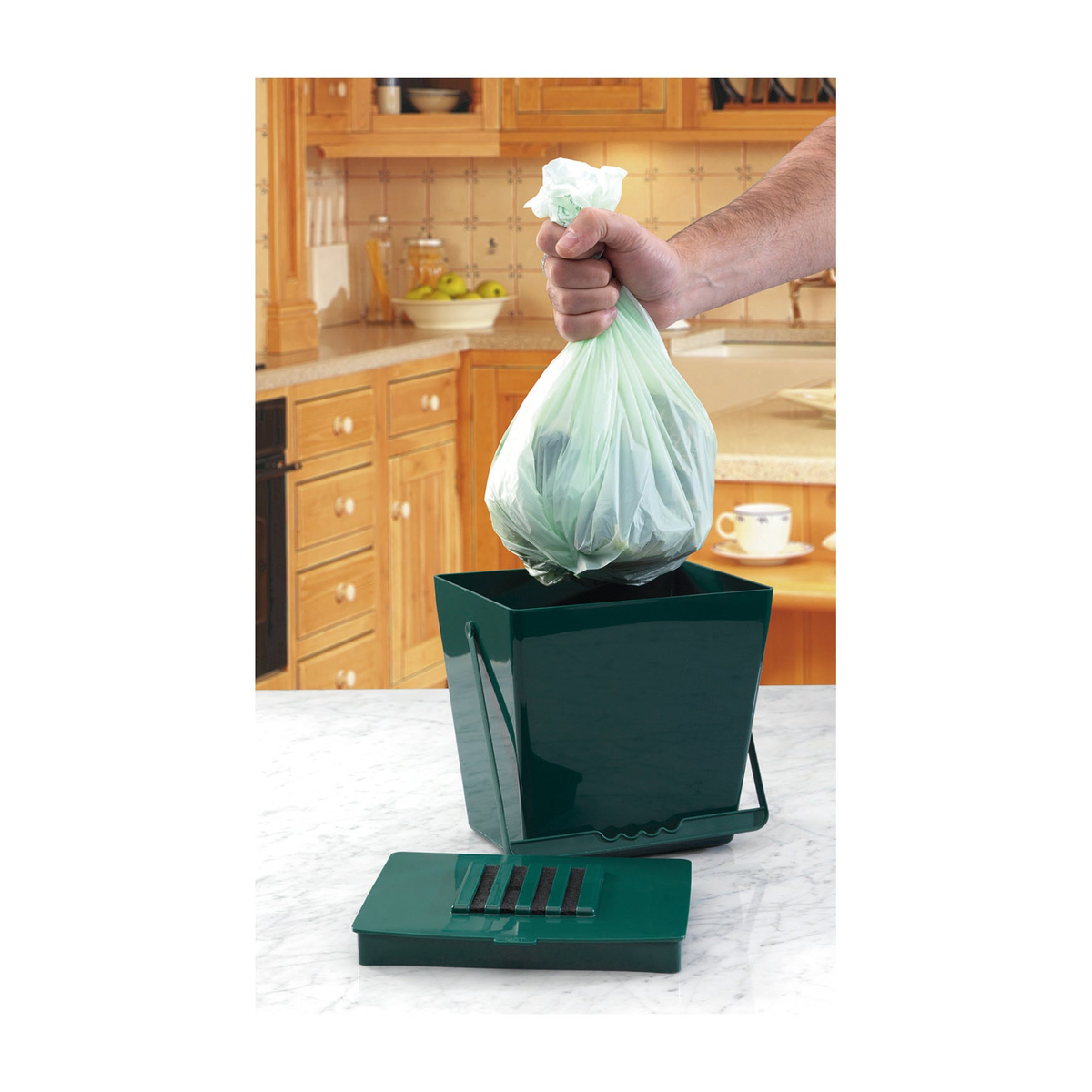 Biodegradable caddy liner in a mini compost caddy, box of 20 bags for eco-friendly waste disposal.