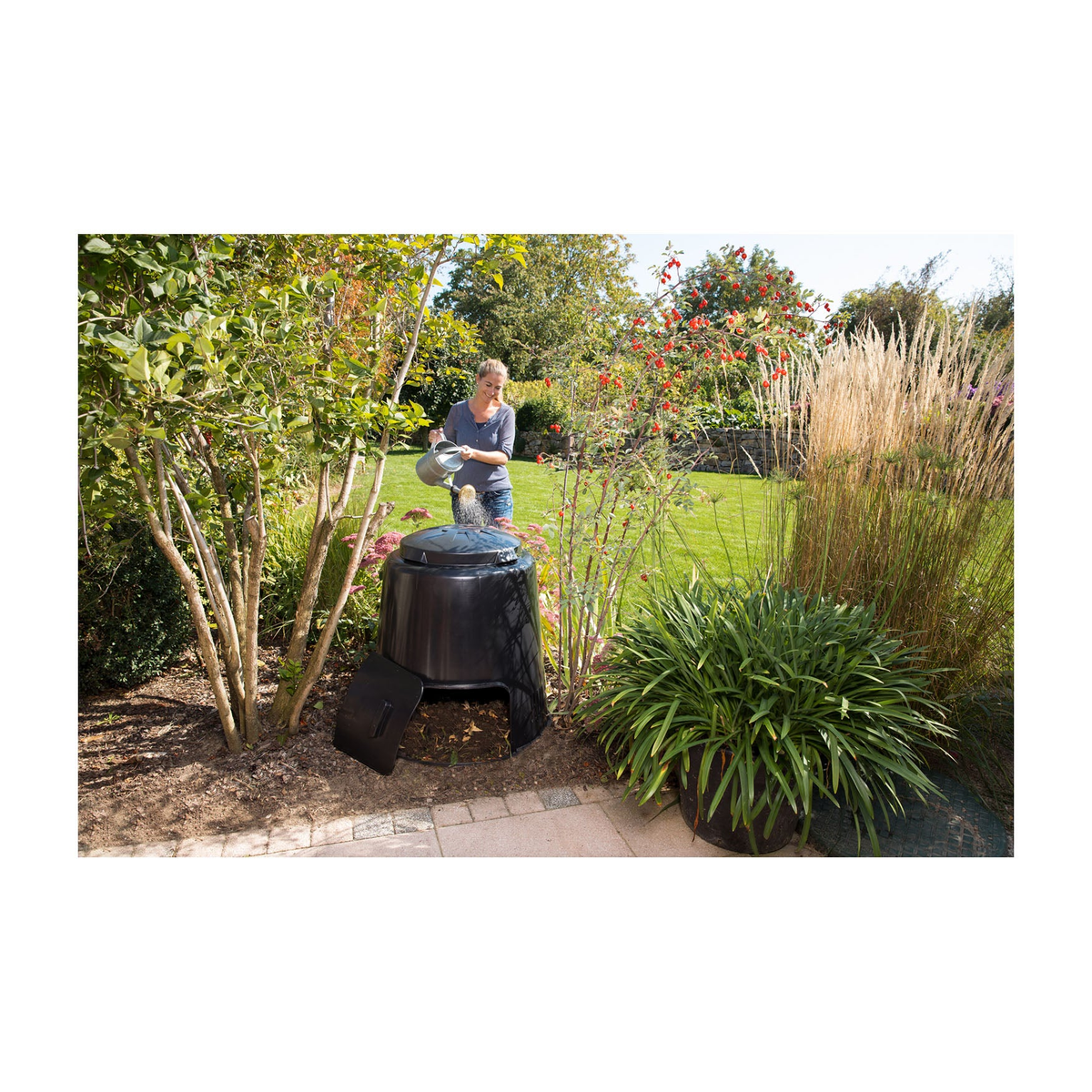 74 Gallon Capacity Eco Composter in garden with woman adding scraps