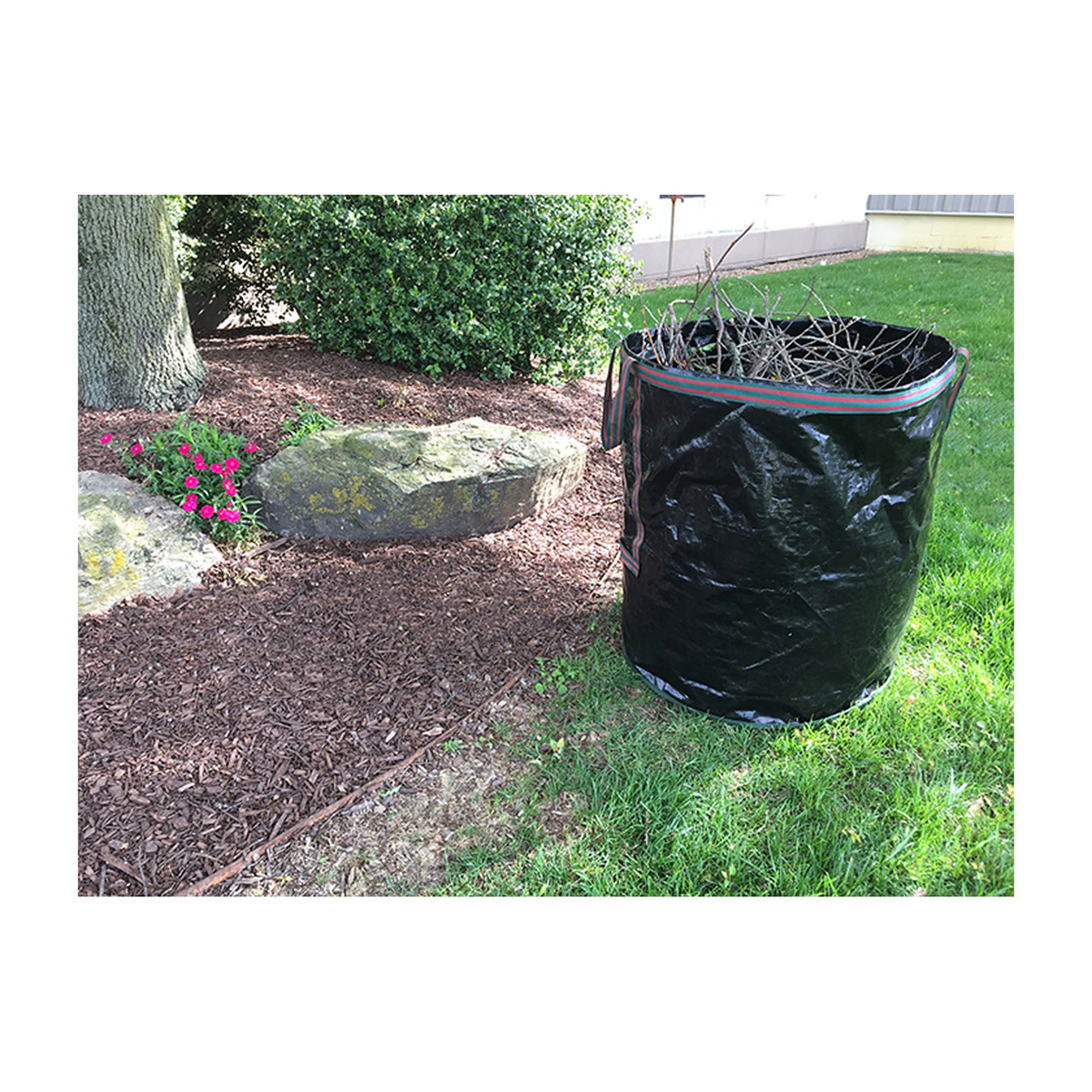 69 gallon deluxe black reusable yard waste tip bag with handles, self-standing design, filled with yard debris.