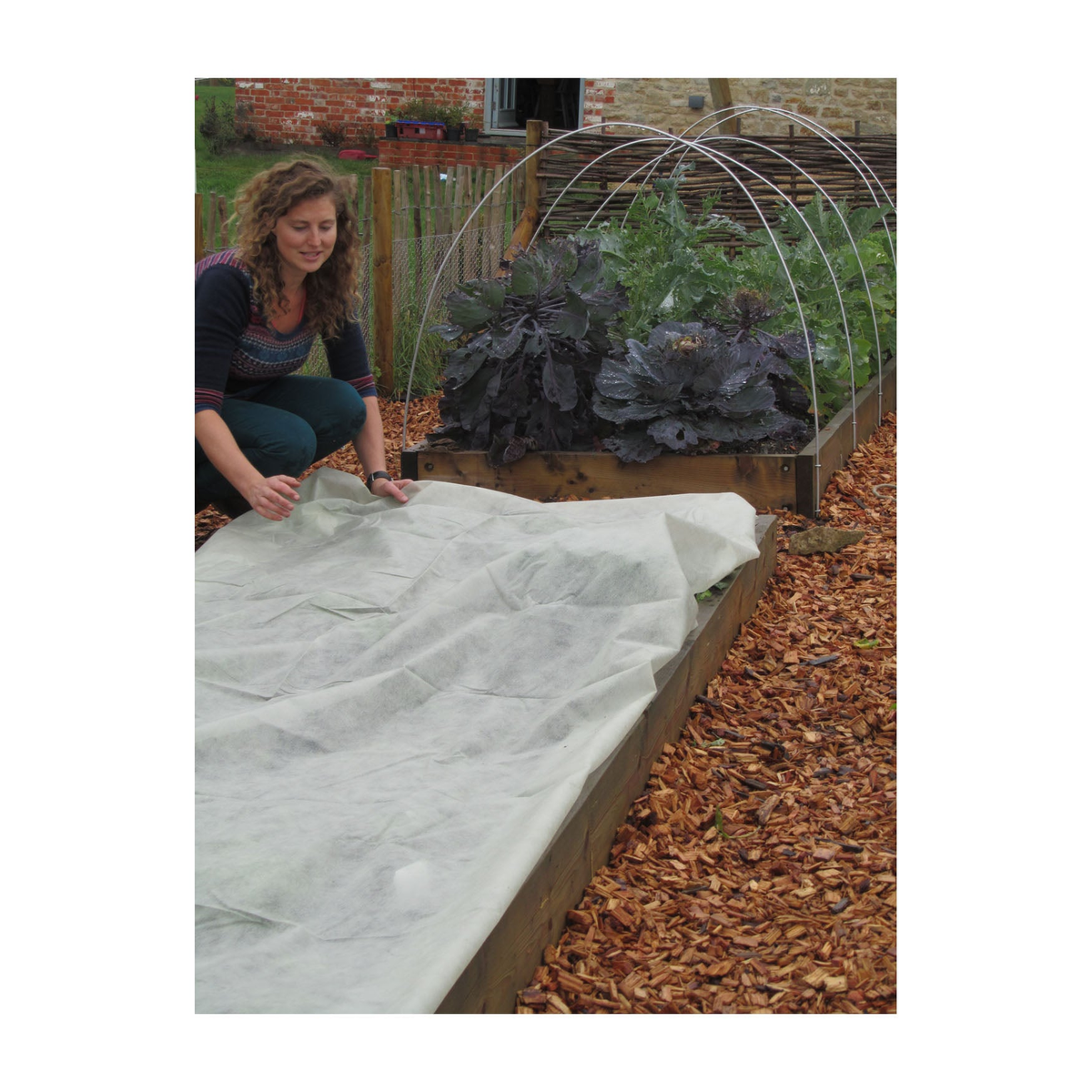 Garden bed covered with extra thick fleece blanket for frost protection.