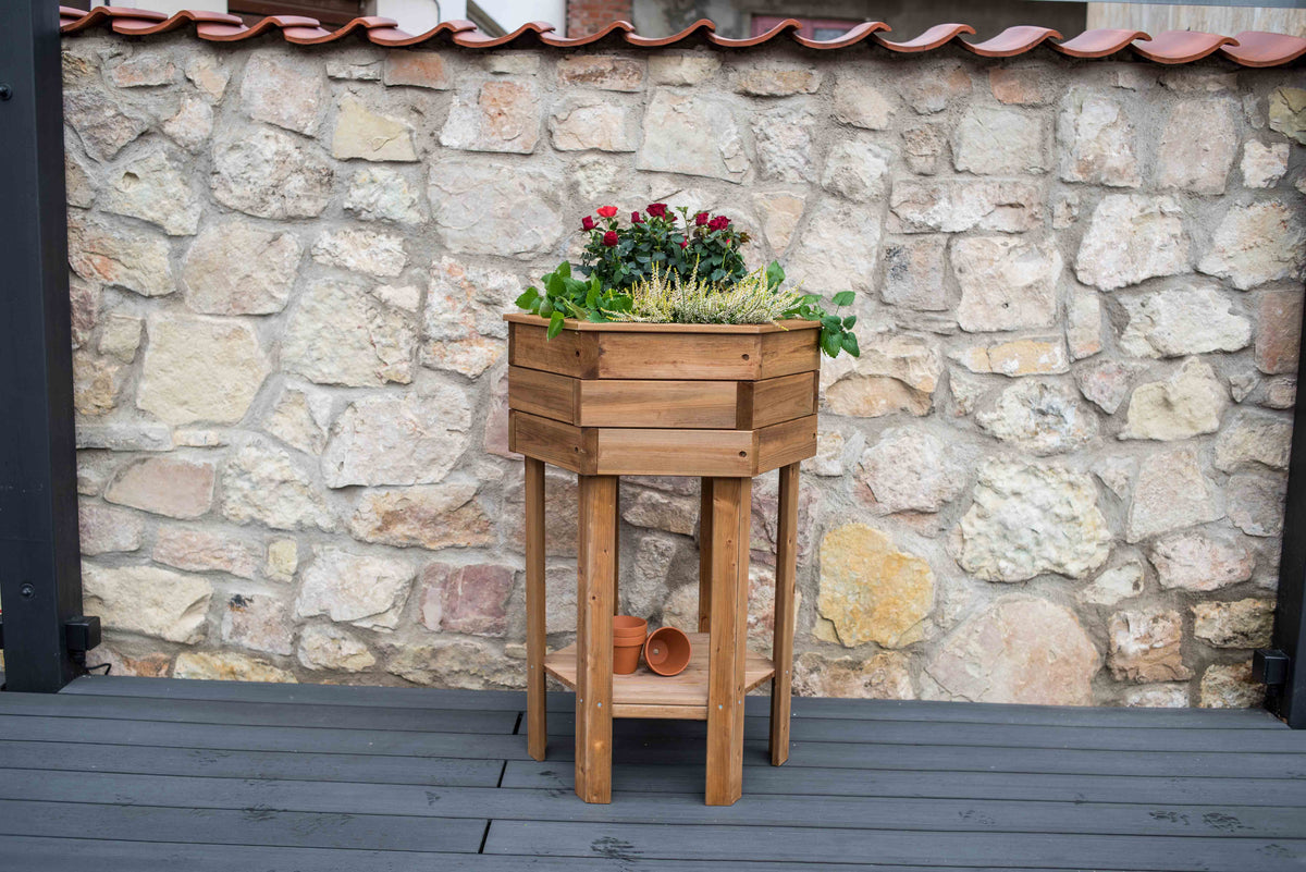 Hexagonal Wooden Raised Flower Bed, 38-inch high, pine and spruce wood, on deck with plants.