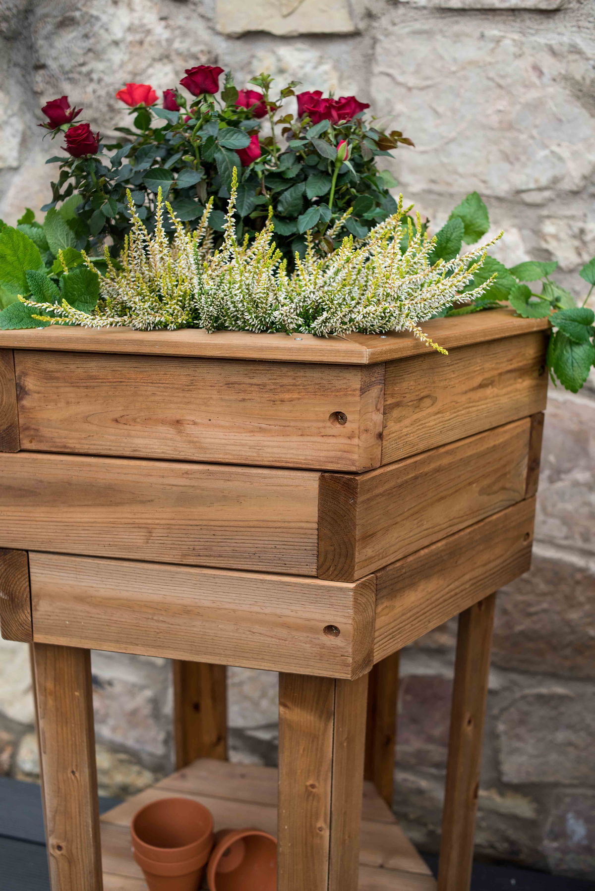 Hexagonal Wooden Raised Flower Bed with plants, made from FSC-certified pine and spruce, treated with linseed oil.