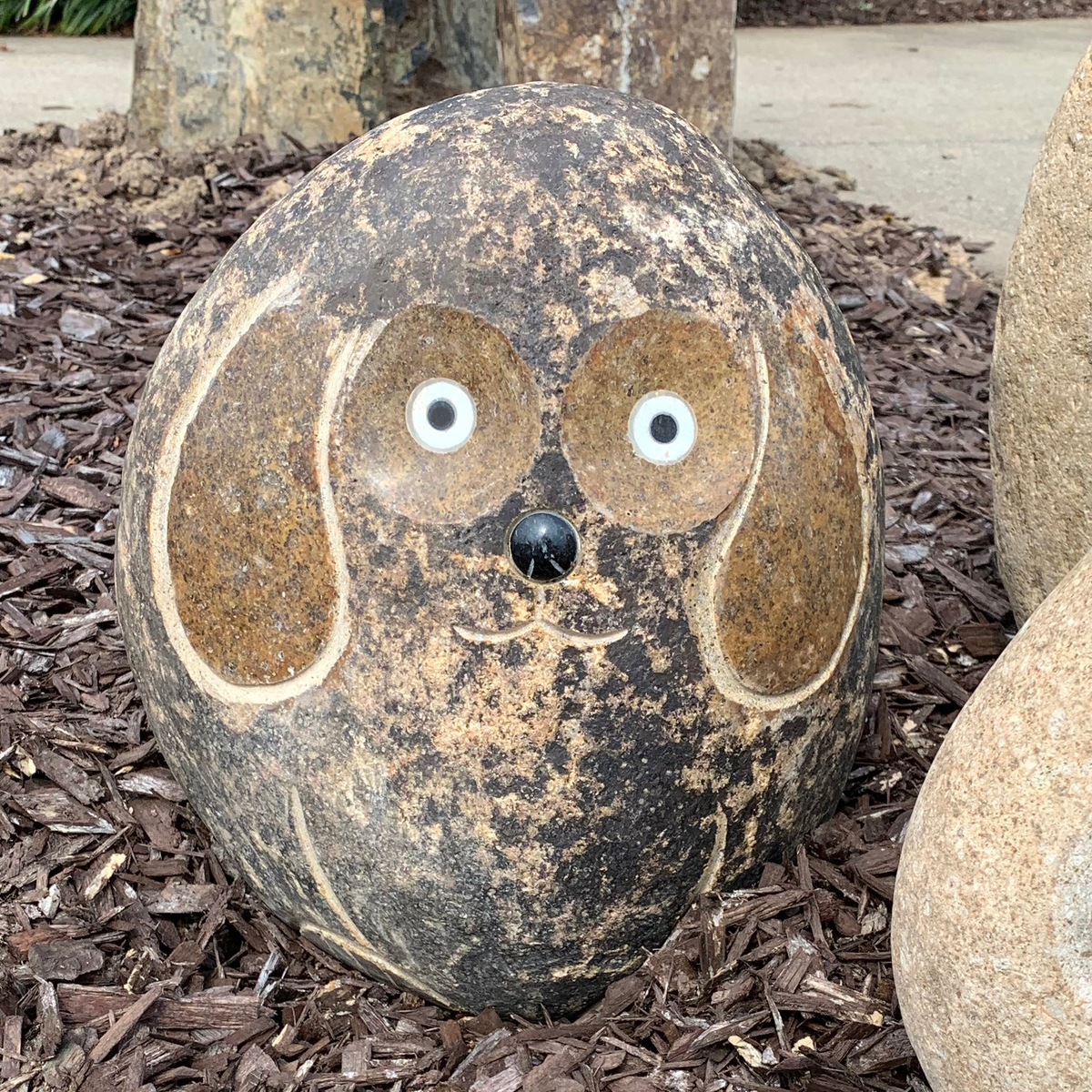 Hand carved natural granite 12-inch boulder stone dog with polished ears, outdoor garden decor.