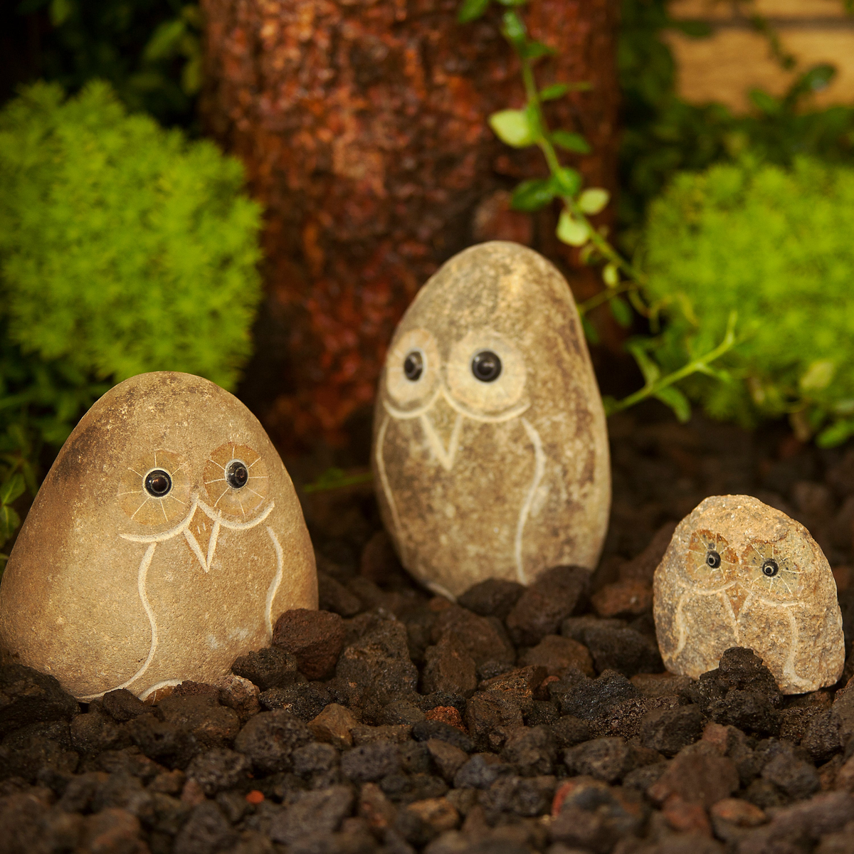 Hand-carved natural granite boulder stone owl sculptures in a family set of three for garden decoration.