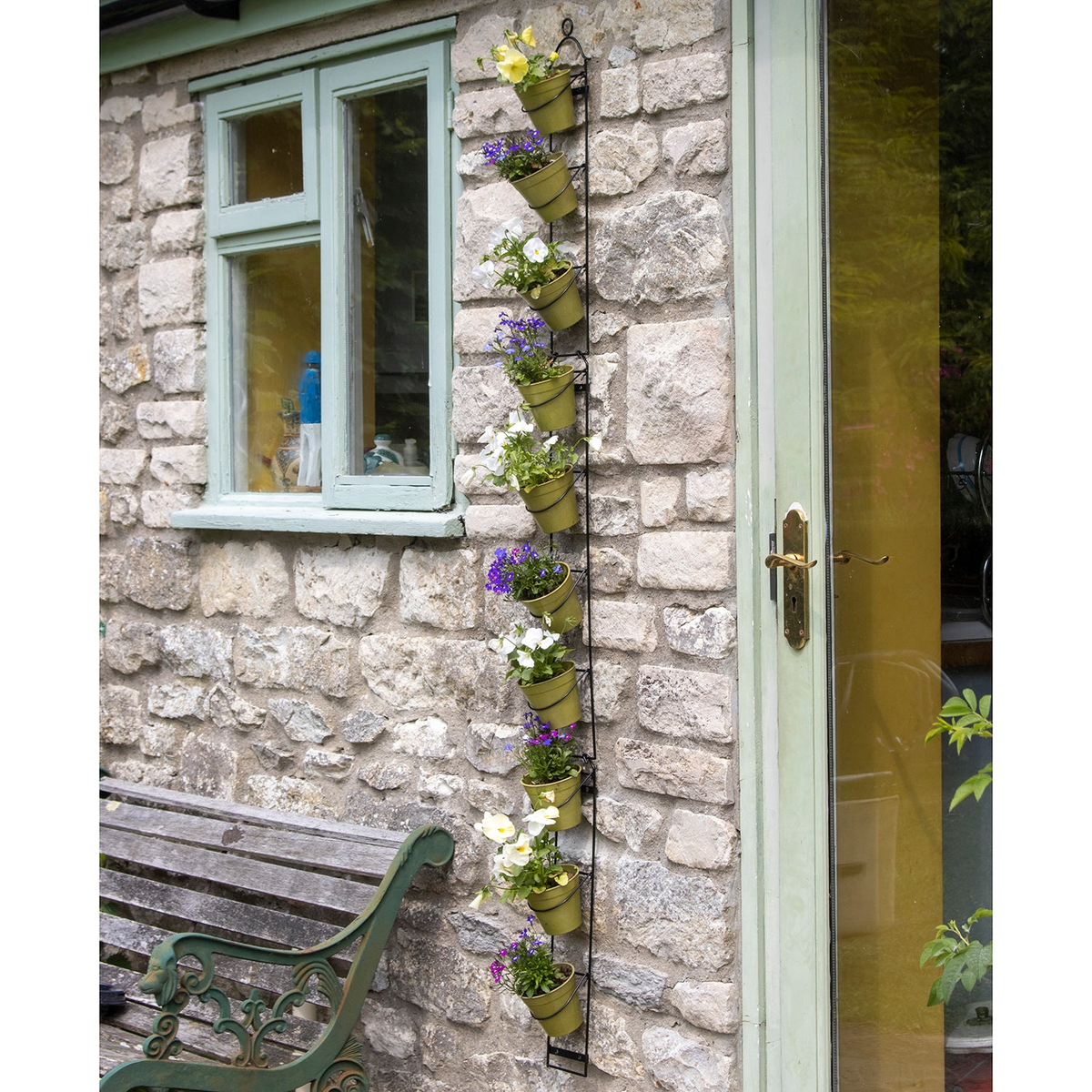 Tall Wall Plant Holder with ten pots, showcasing a vibrant vertical garden on a stone wall.