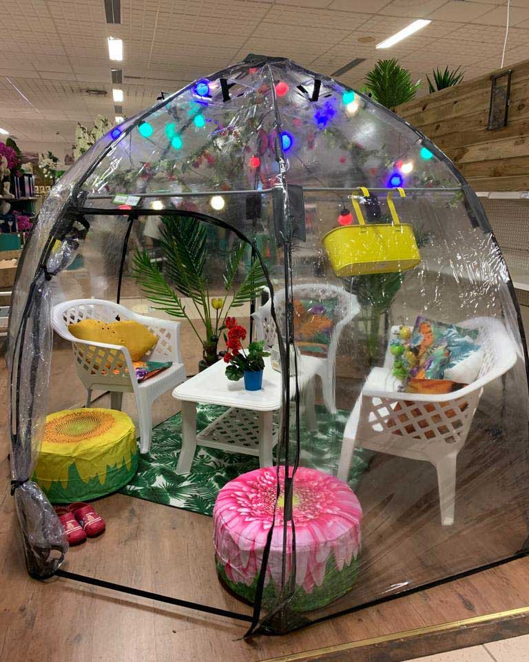 Standard Sunbubble Walk-In Greenhouse with seating inside displayed indoors, featuring a dome shape with colorful decor and plants.