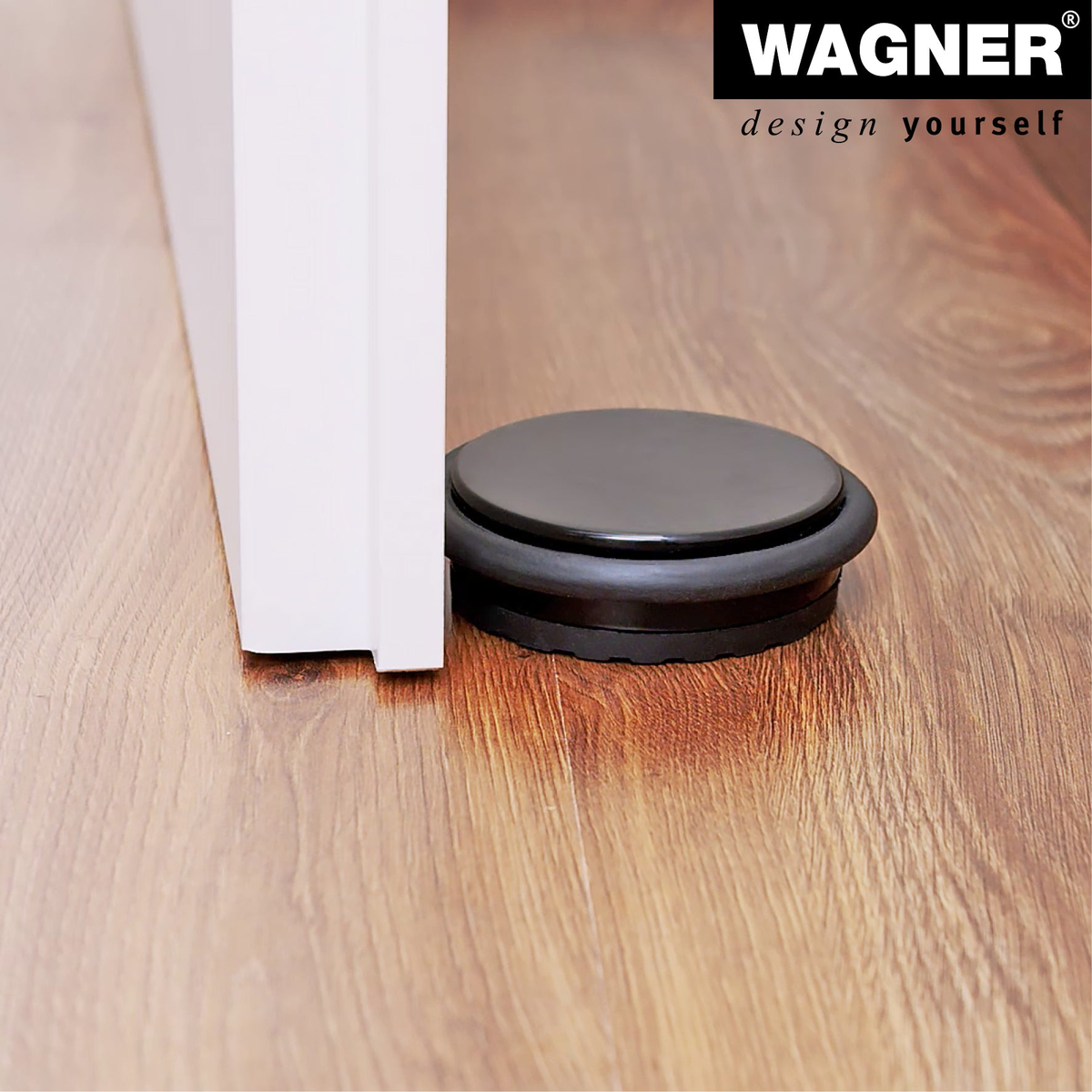 Black floor mount door stopper by WAGNER with thermoplastic rubber pad for slip resistance, measuring 3.86&quot; x 3.86&quot; x 1.18&quot;.