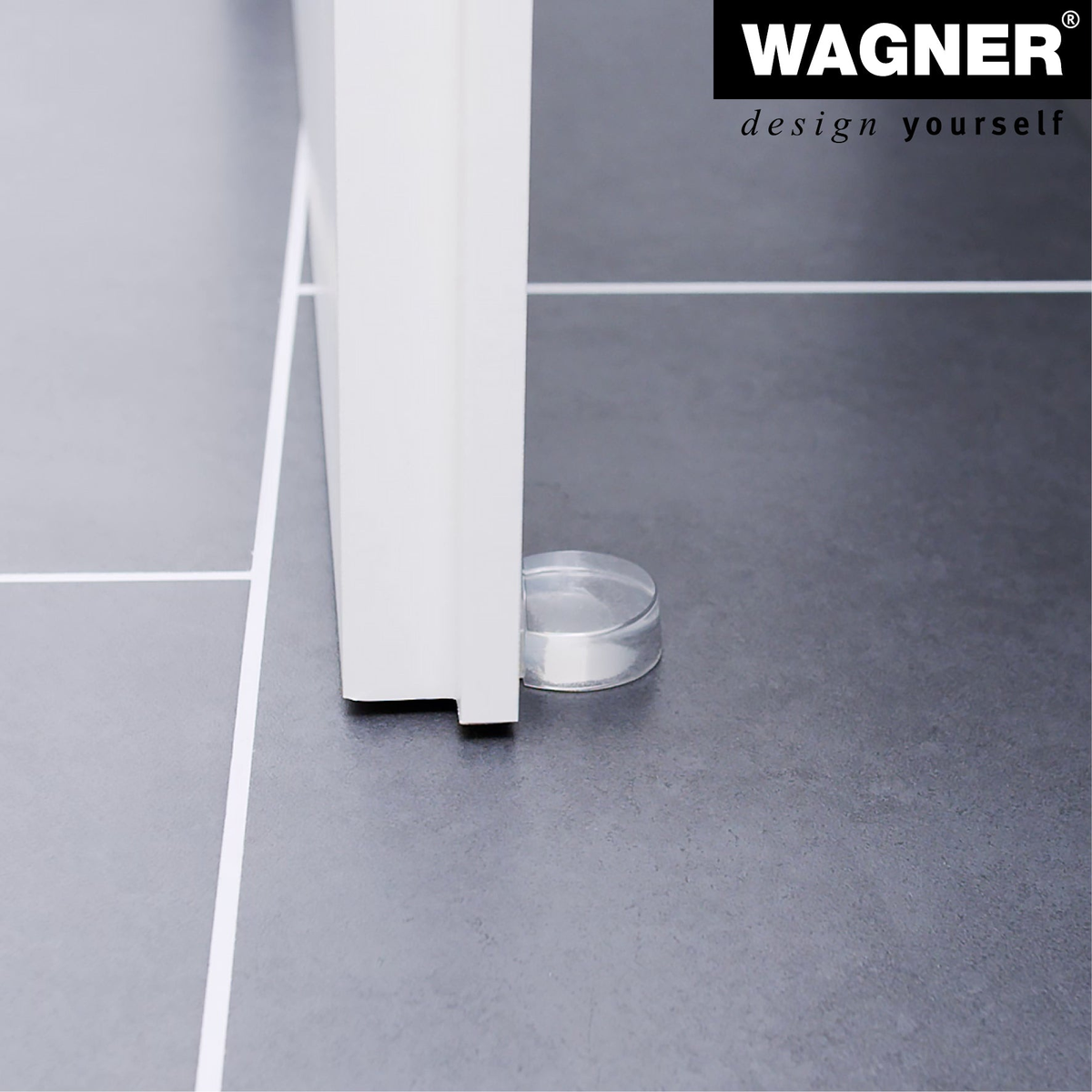 Clear door stopper with adhesive mount on a floor, dimensions 1.77 x 1.54 x 0.63 inches, by Wagner.