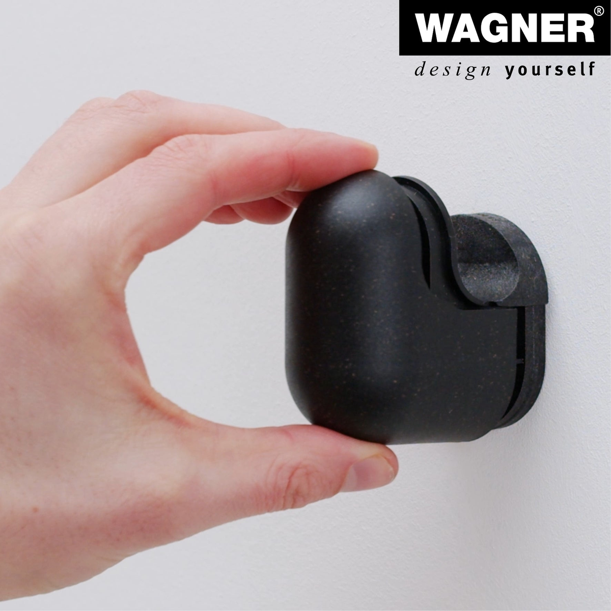 Black rubber and steel wall hook being mounted on a wall, part of the Wagner multipurpose hooks 4 pack.