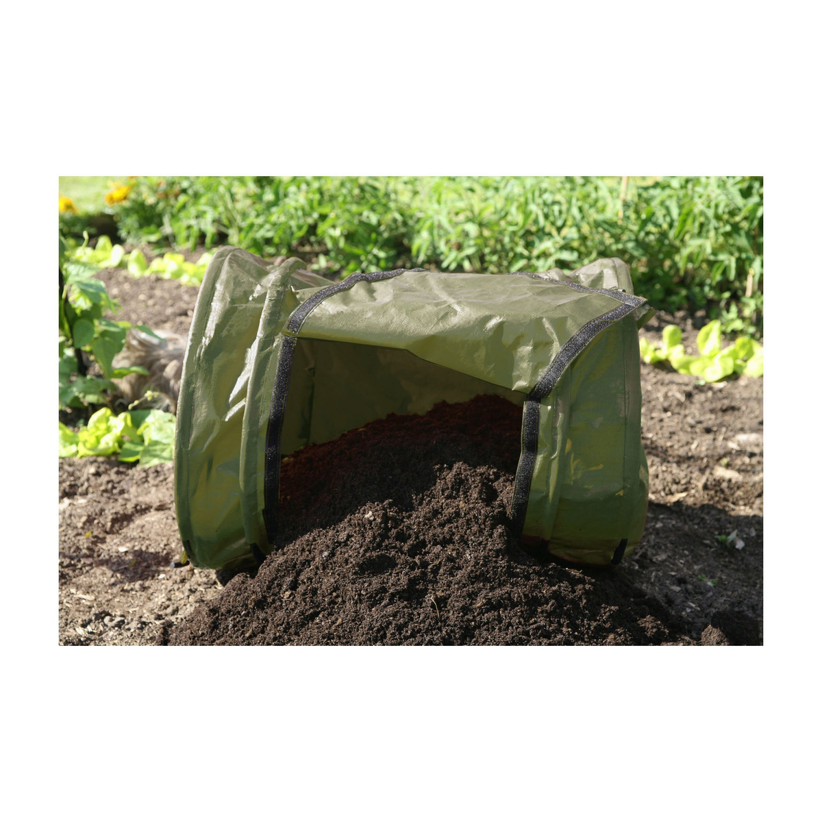 Rollmix Composter on soil in garden setting.